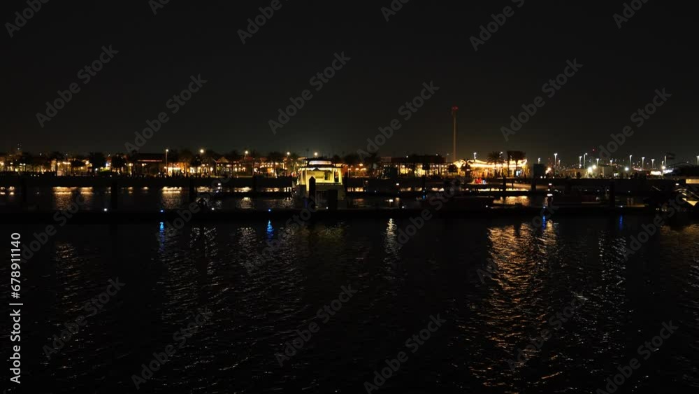 Night view of Hudayriyat Beach with illuminated city and the reflection in the water in Abu Dhabi Night view of Hudayriyat Beach with illuminated city and the reflection in the water in Abu Dhabi