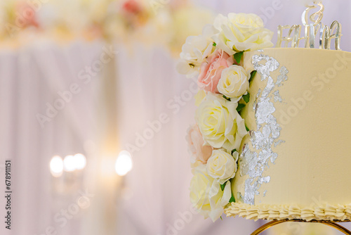 Beautiful creamy yellow wedding cake decorated with roses