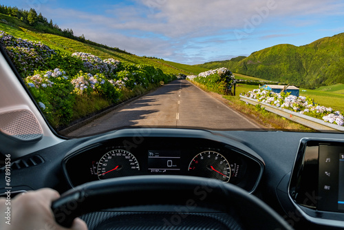 Driver view to the road with beautiful green landscape view from inside stoped car of driver POV of the road landscape. São Miguel island in the Azores, Portugal, Europe. photo