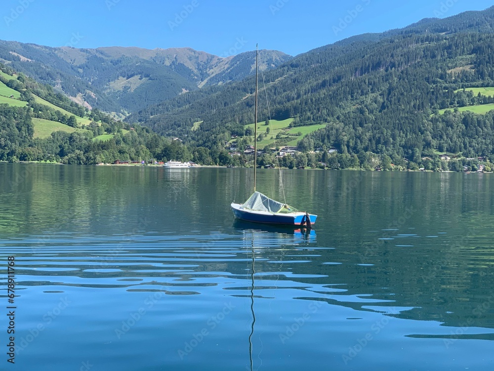 Boat in Lake Zell with range green mountains in Austria with blue sky