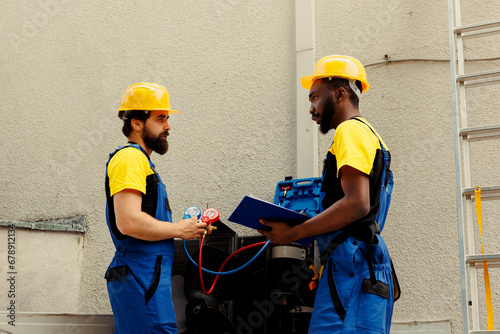 Фотография Licensed electricians contracted to do air conditioner check, refilling refrigerant
