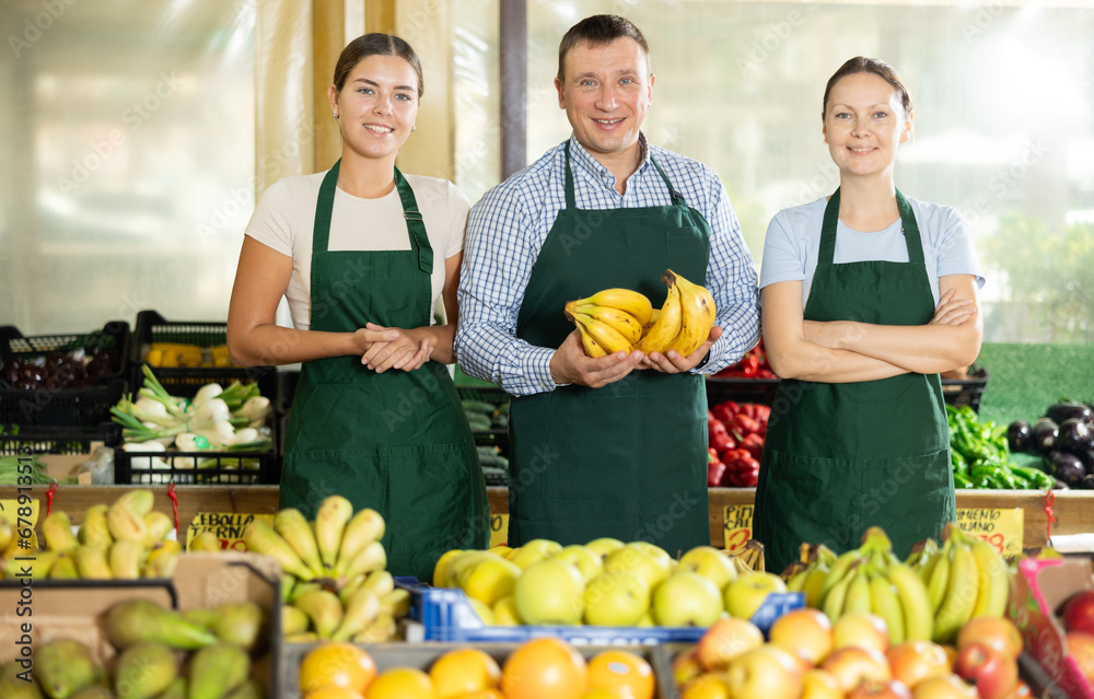 Portrait of three salespeople in the fruit and vegetable department of a supermarket