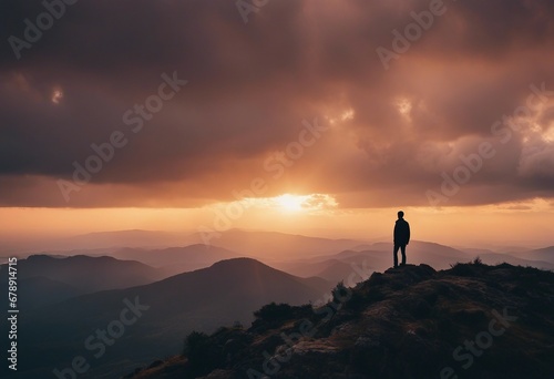 A person standing on top of a mountain at sunset image