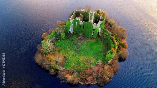 Aerial of the McDermott's Castle and a national monument in Ireland surrounded by the tranquil sea