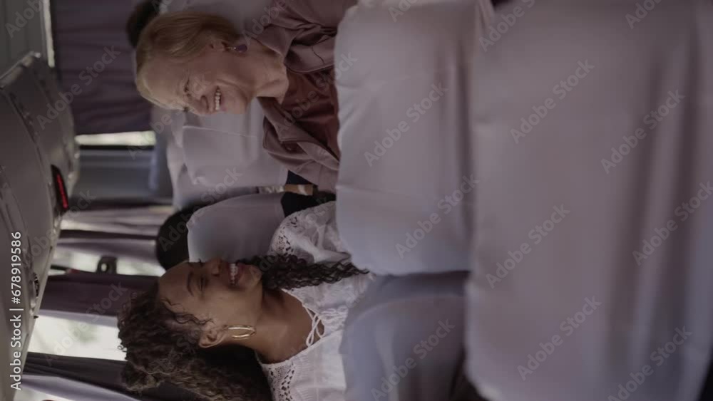 Duas mulheres de idades diferentes, sentadas lado a lado em um onibus, conversando. Cinematico 4k. Video vertical.