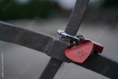 Closeup of a heart-shaped lock on a bridge as a concept of eternal love