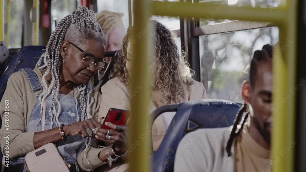 Mulher idosa mostrando algo em seu celular para uma mulher no onibus. Cinematico 4k.