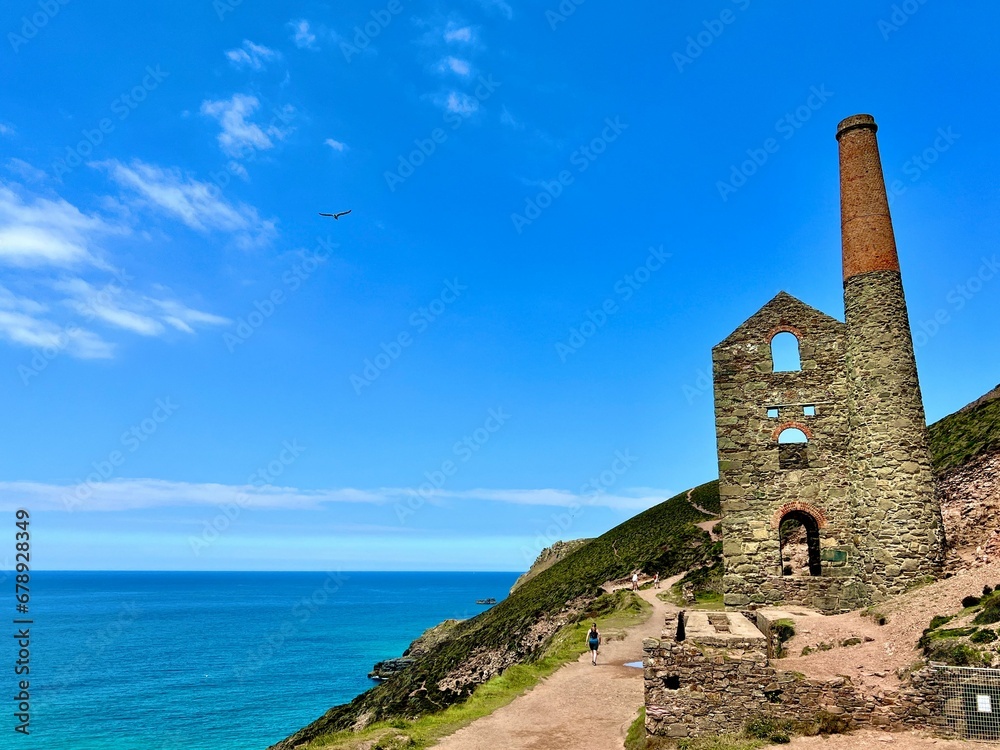 two chimneys sit on the edge of a rocky cliff next to a body of water two chimneys sit on the edge of a rocky cliff next to a body of water