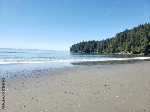 Natural view of a beautiful beach and a forested island on a sunny day