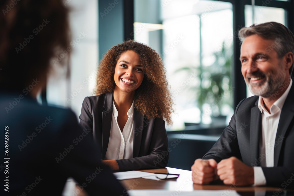Female financial adviser meeting with clients in an office displaying confident women in the workplace - obrazy, fototapety, plakaty 