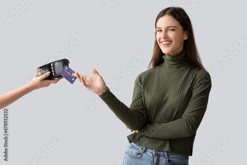 Young woman paying with cre...