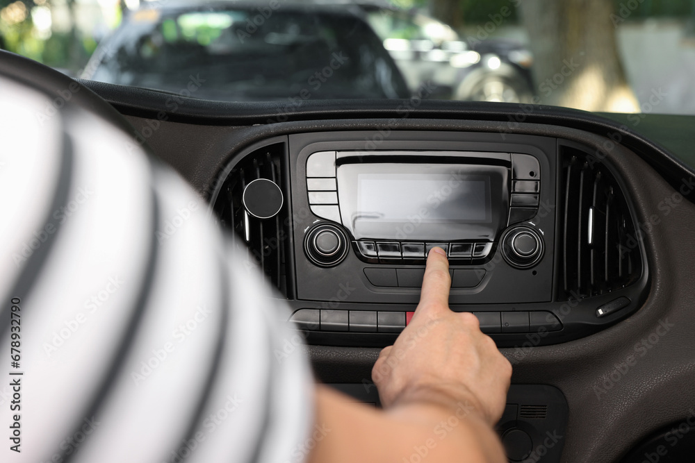 Choosing favorite radio. Man pressing button on vehicle audio in car, closeup