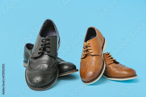 Stylish child's leather shoes on color background