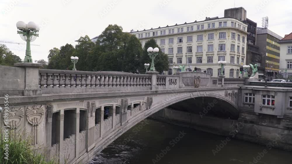 The Dragon bridge, and old stone bridge spanning the Ljubljanica river in central Ljubljana, Slovenia The Dragon bridge, and old stone bridge spanning the Ljubljanica river in central Ljubljana, Slovenia