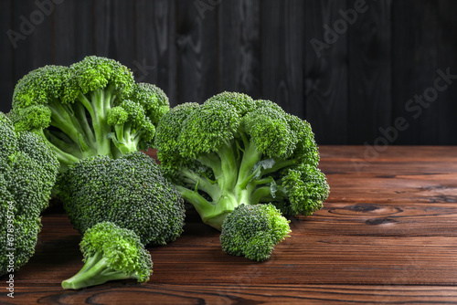Fresh raw broccoli on wooden table, closeup. Space for text