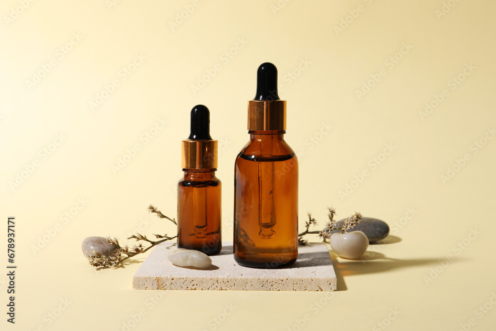 Composition with bottles of cosmetic serum on beige background