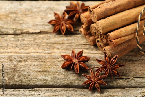 Cinnamon sticks and star anise on wooden table, closeup. Space for text