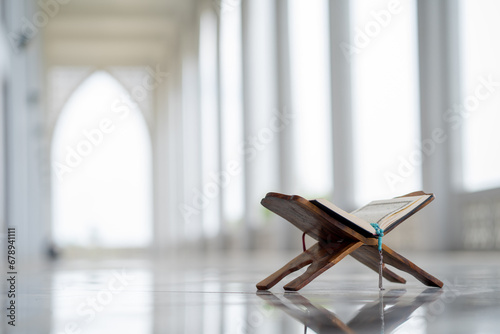 Islamic concept - The Holy Al Quran with written Arabic calligraphy meaning of Al Quran and rosary beads or tasbih, Arabic word translation: The Holy Al Quran (holy book of Muslim) 