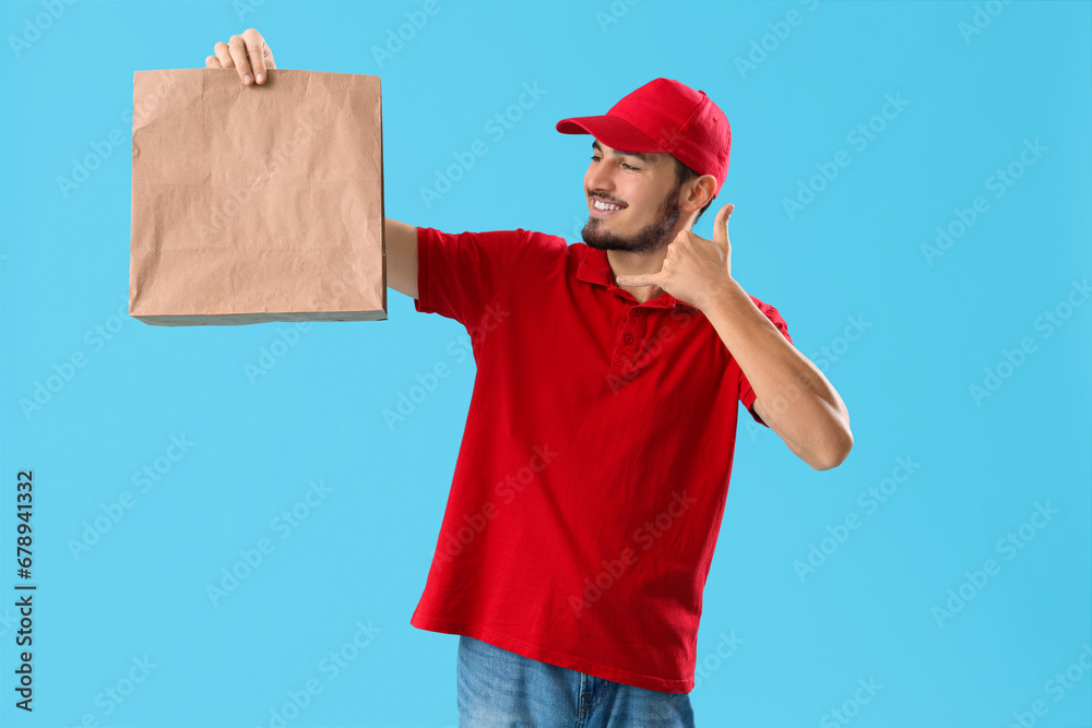 Worker of food delivery service with paper bag showing Worker of food delivery service with paper bag showing
