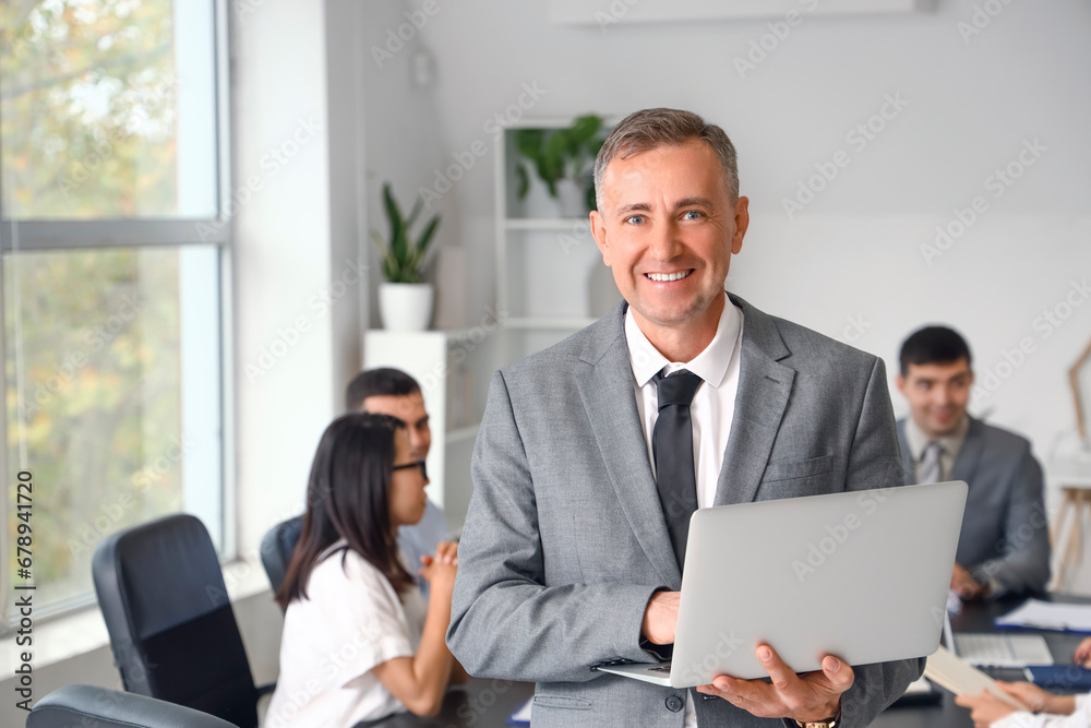 Mature businessman working with laptop in office Mature businessman working with laptop in office