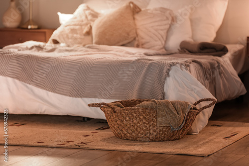 Fototapeta Naklejka Na Ścianę i Meble -  Wicker basket with plaid in bedroom
