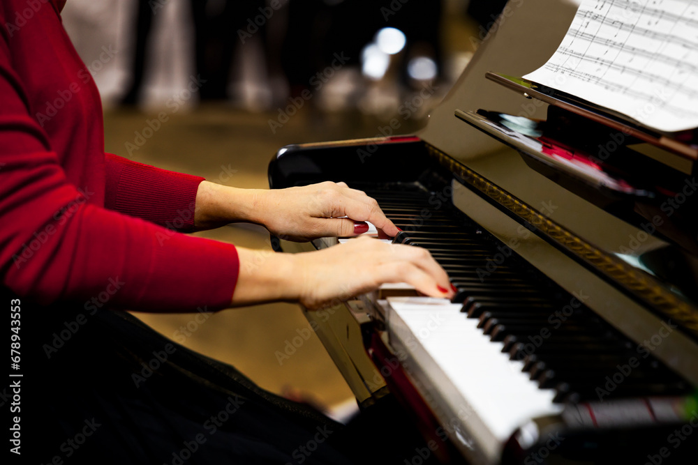 Obraz premium Pianist playing a grand piano. Close up of female hands playing the piano.