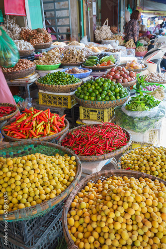 Baskets of different types of dried fruit, herbs, vegetables in an outdoor market on Hanoi street