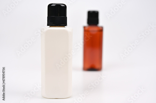 白いボトルの背後に茶色のボトル