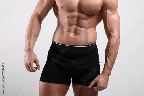 Young man is stylish black underwear on light grey background, closeup