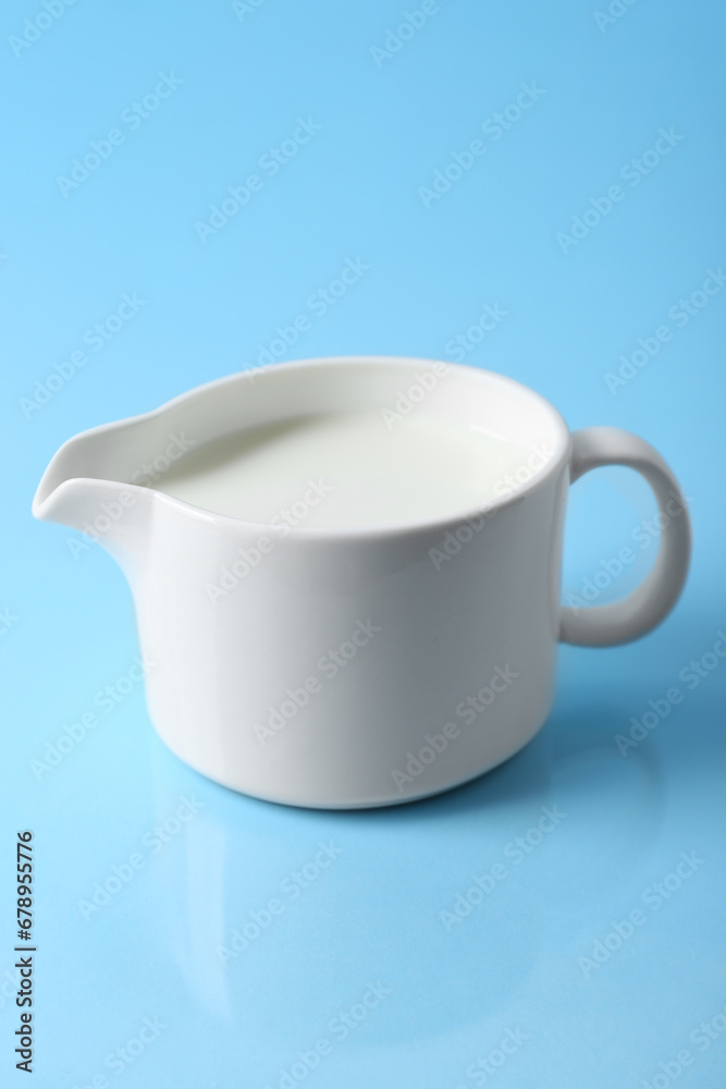 Jug of fresh milk on light blue background Jug of fresh milk on light blue background