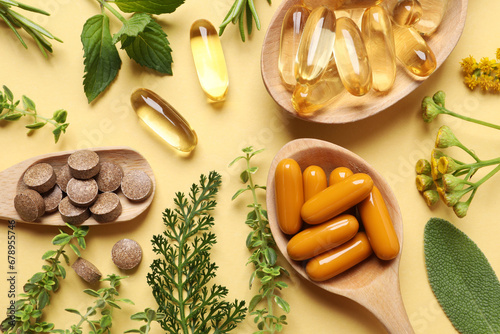 Different pills and herbs on pale orange background, flat lay. Dietary supplements photo