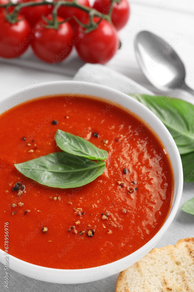 Delicious tomato cream soup in bowl served on table, closeup Delicious tomato cream soup in bowl served on table, closeup