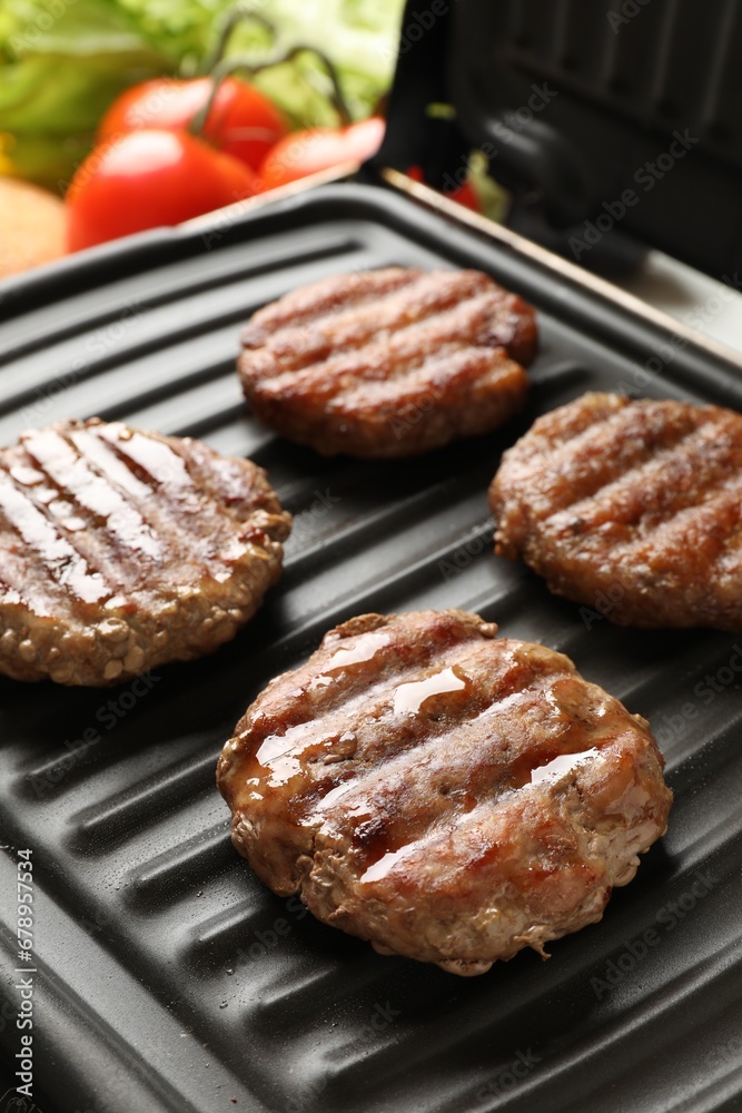 Delicious hamburger patties cooking on electric grill Delicious hamburger patties cooking on electric grill
