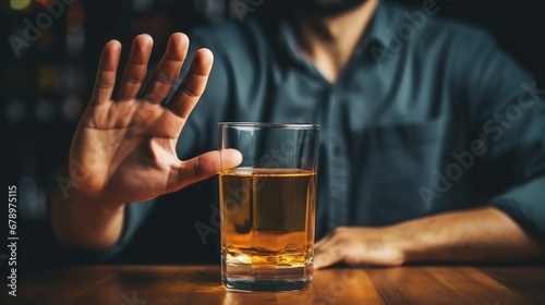 man smile and refuses say no and avoid to drink an alcohol whiskey , stopping hand sign male, alcoholism treatment, alcohol addiction, quit booze, Stop Drinking Alcohol. Refuse Glass liquor photo