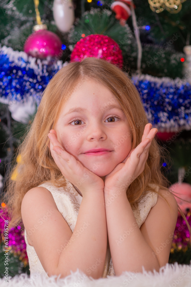 A beautiful elegant girl near the Christmas tree in the New Year. Holiday. New Year. The child is a model. A beautiful elegant girl near the Christmas tree in the New Year. Holiday. New Year. The child is a model.