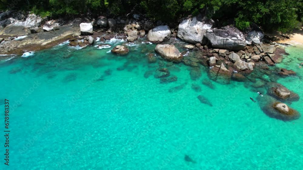 Drone video of 2 people snorkelling near huge granite stones, white sandy beach, turquoise transparent Indian ocean water, Mahe, Seychelles 30fps Drone video of 2 people snorkelling near huge granite stones, white sandy beach, turquoise transparent Indian ocean water, Mahe, Seychelles 30fps