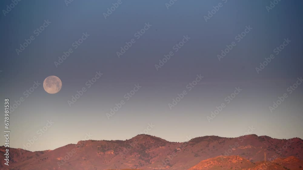 Full moon in the morning on sky over mountain.