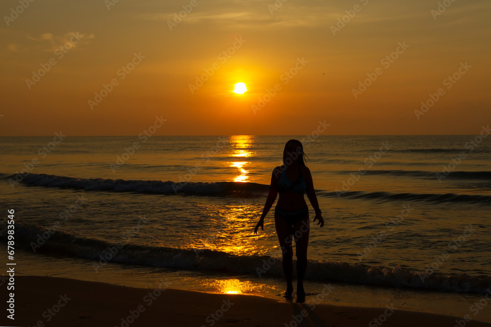 Woman body big with bikini and sunrise on beach