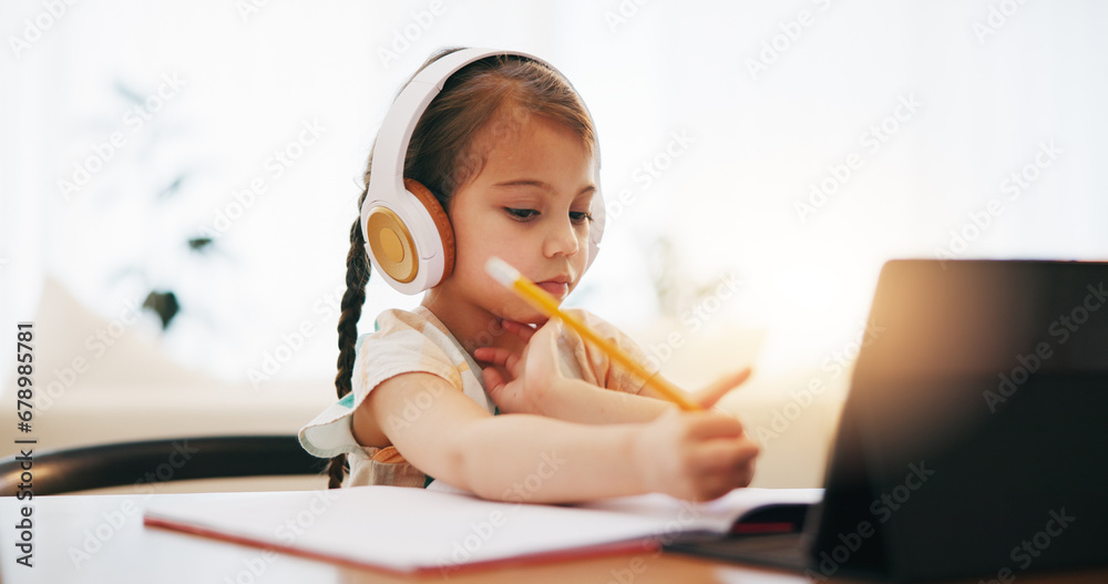 Girl, headphones and writing in book for elearning, education or study on desk at home. Female person, little child or kid taking notes with tablet, headset or technology for virtual class at house Girl, headphones and writing in book for elearning, education or study on desk at home. Female person, little child or kid taking notes with tablet, headset or technology for virtual class at house