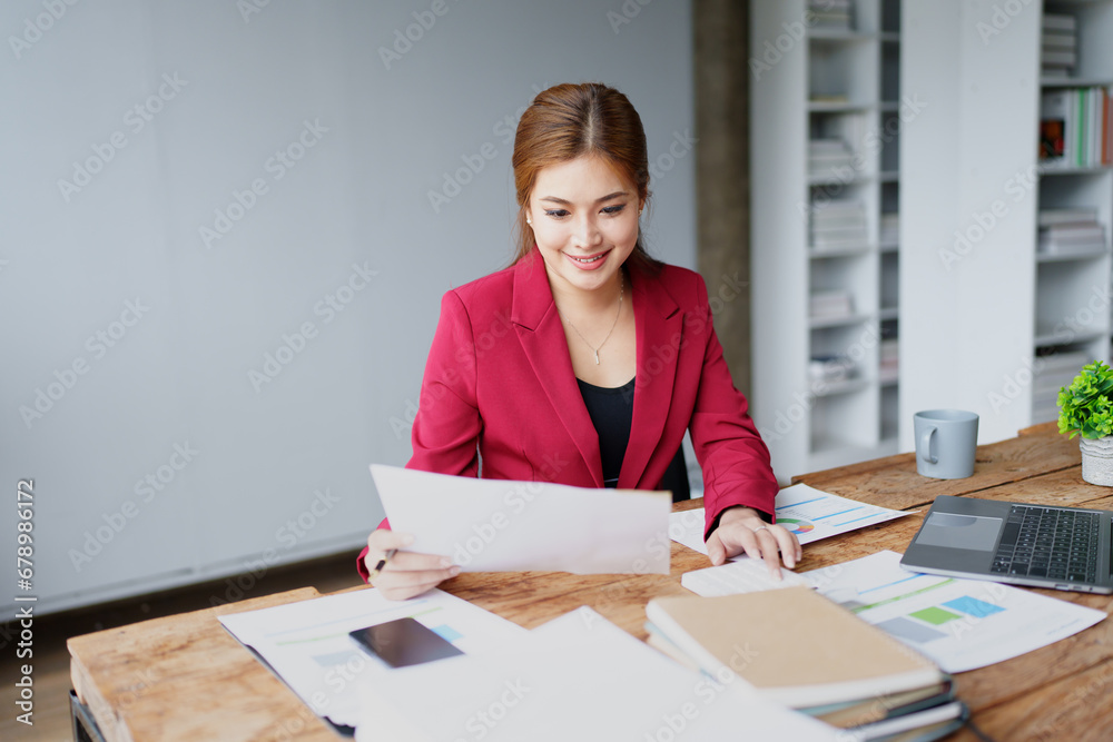 businesswoman or accountant working on calculator and laptop computer to calculate business data during using accountancy document at office businesswoman or accountant working on calculator and laptop computer to calculate business data during using accountancy document at office