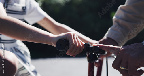 Parent, child and teaching bicycle ride for safety, closeup and outdoor street with hands. Cycling, childhood memory and riding in summer, bonding together and recreation with bike bell for alert photo