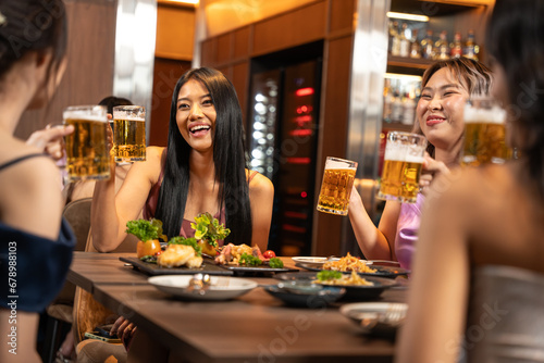 Beautiful Asian woman is Relishing a Delightful Dinner with Friends at a Bar  Immersed in the Joy of a Vibrant Night Party. They Enjoying with Night Party Together. Party and Celebration Concept.
