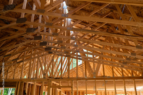 The wooden rafters above the future living area at a new home construction building site.