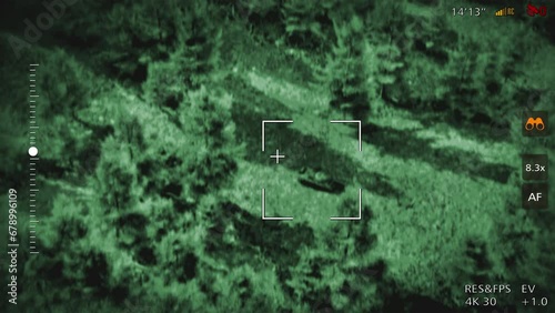 Night vision military drone flying above the battlefield. Night vision military drone looking for enemy vehicles in the area. Night vision military drone striking the enemy tank with explosive weapon.