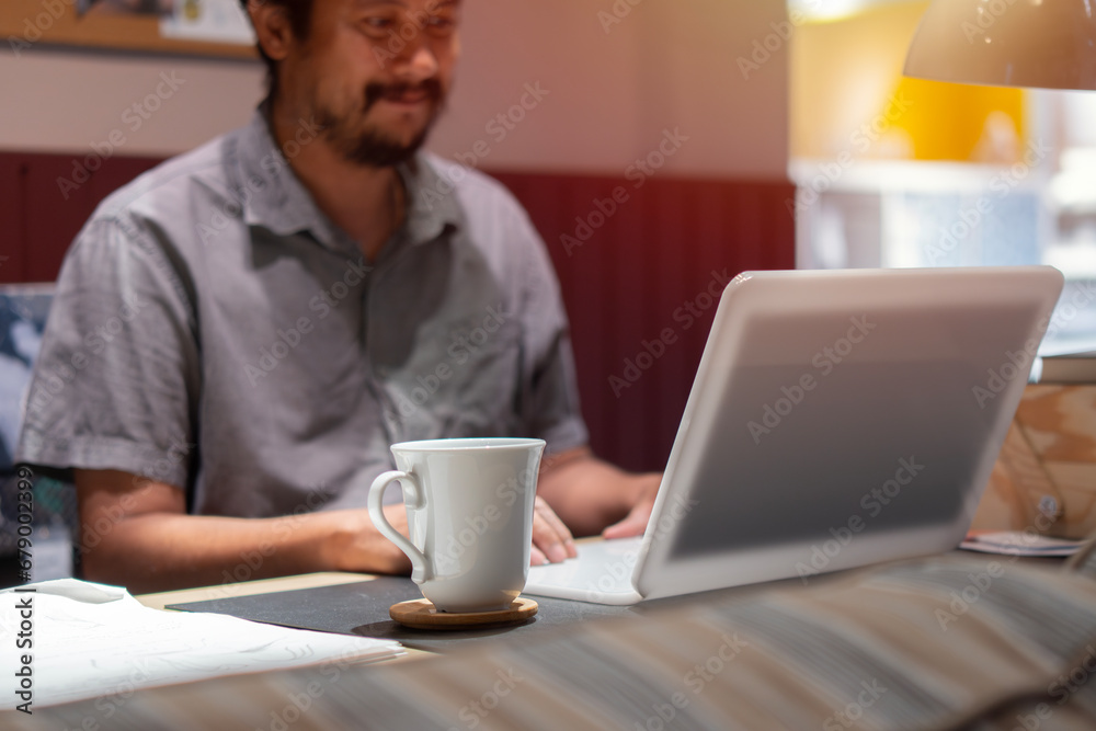 Businessman sitting in in office working with laptop computer. Mature age, middle age, mid adult man in 40s with happy confident smile. Businessman sitting in in office working with laptop computer. Mature age, middle age, mid adult man in 40s with happy confident smile.
