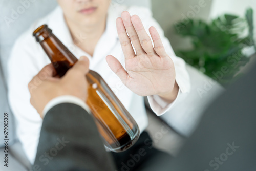 man refuses say no and avoid to drink an alcohol , hand show reject and stopping, alcoholism treatment, alcohol addiction, quit booze, Stop Drinking Alcohol. Refuse bottle liquor, unhealthy photo