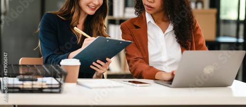 Obraz na plátně Two professional caucasian with african american businesswoman friends collabora
