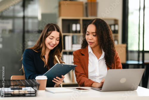 Two professional caucasian with african american businesswoman friends collaboration, working together at office, using laptop, Generally accepted audit standards, Earnings before interest and taxes