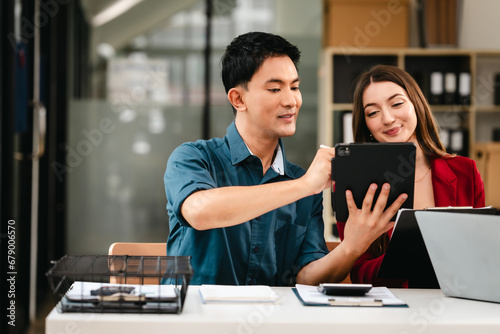 Diverse group of professionals engaging in discussion with laptop and clipboard, in bright office environment. qualified auditor report and opinion, asian people, african american, caucasian female
