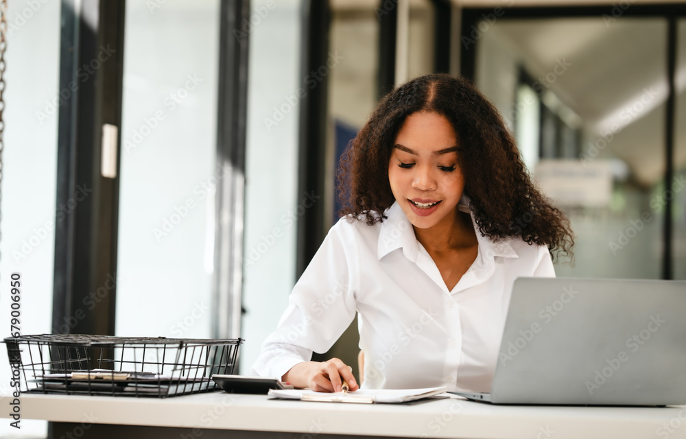 African American businesswoman, focused on her work on a laptop, possibly managing industrial production tasks. African American businesswoman, focused on her work on a laptop, possibly managing industrial production tasks.